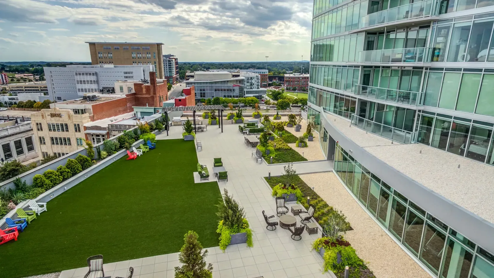 Rooftop lounge area with seating, artificial turf, and city views.