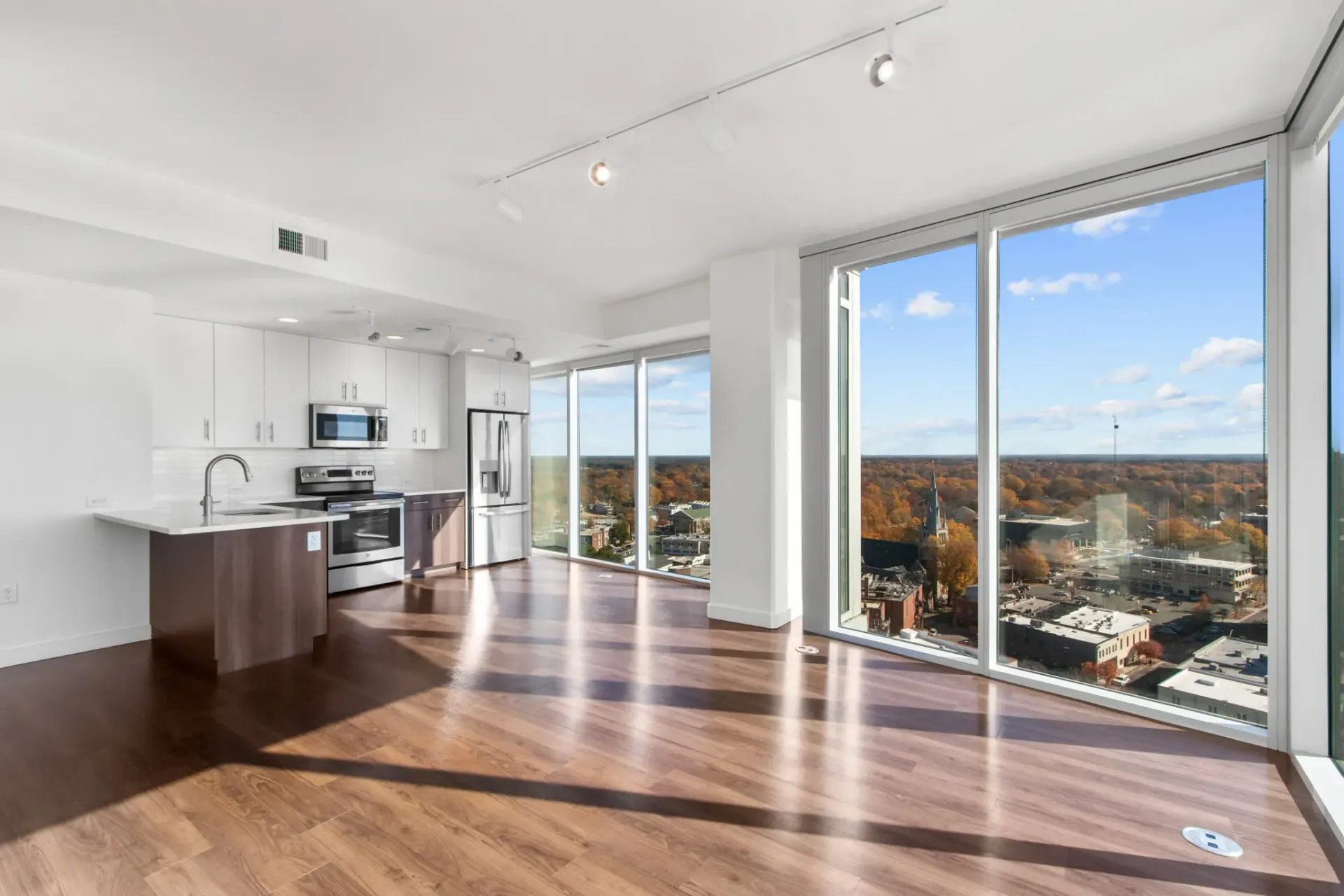 Modern kitchen and living area with floor-to-ceiling windows and city views
