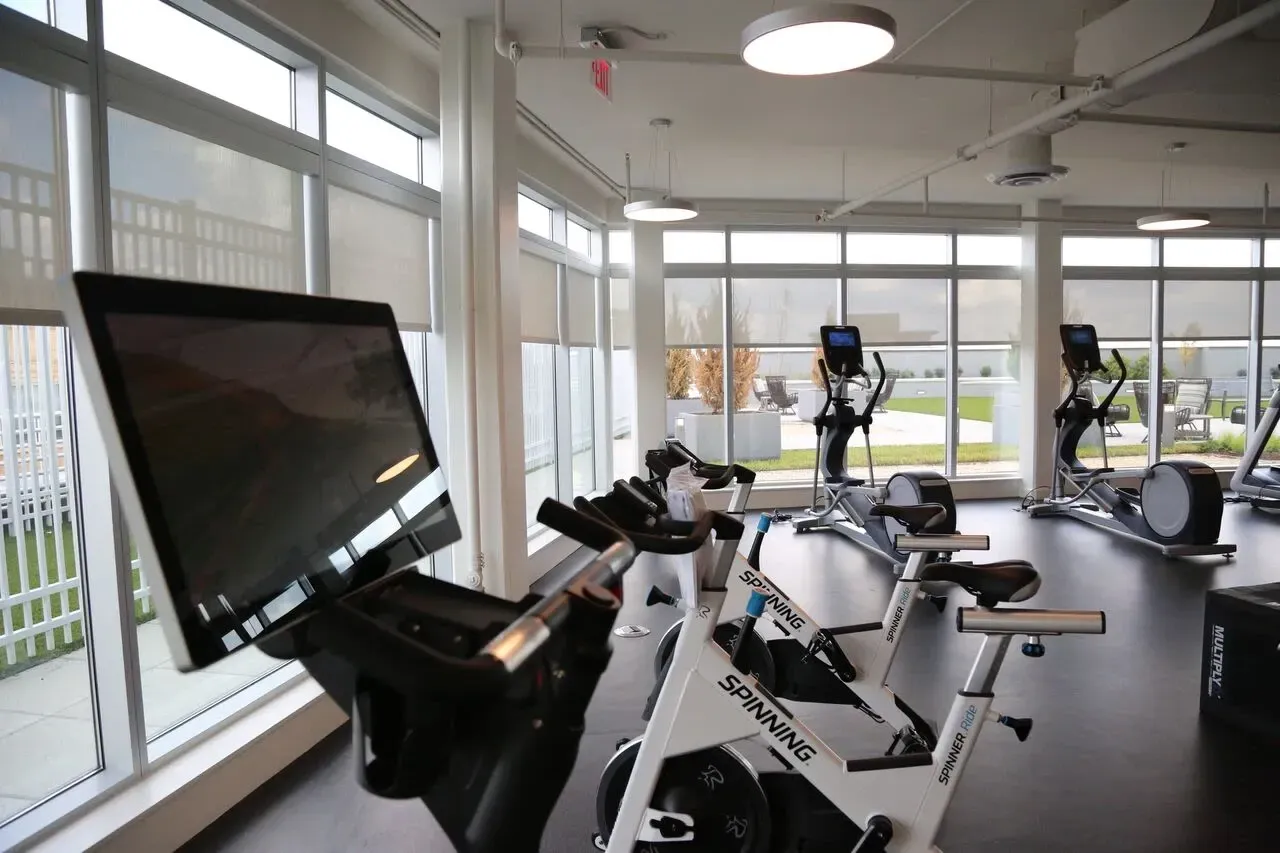 Indoor fitness center with spin bikes and elliptical machines.