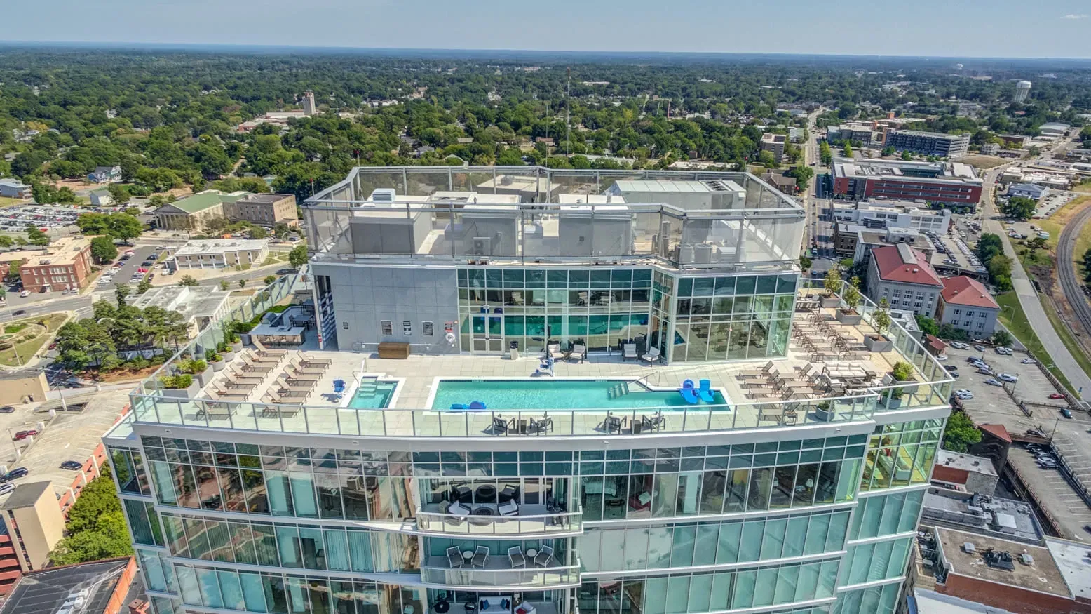 Rooftop swimming pool and lounge area of a modern high-rise apartment building.