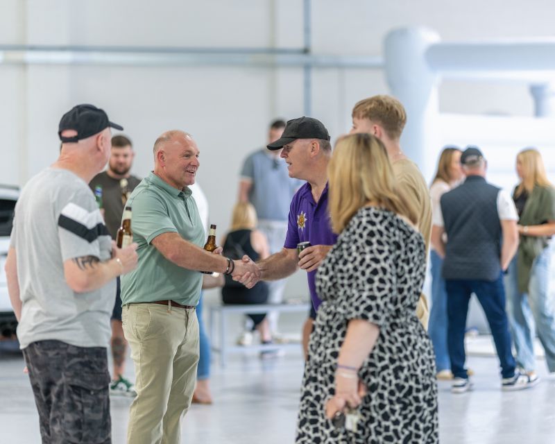 A group of people chatting and shaking hands.