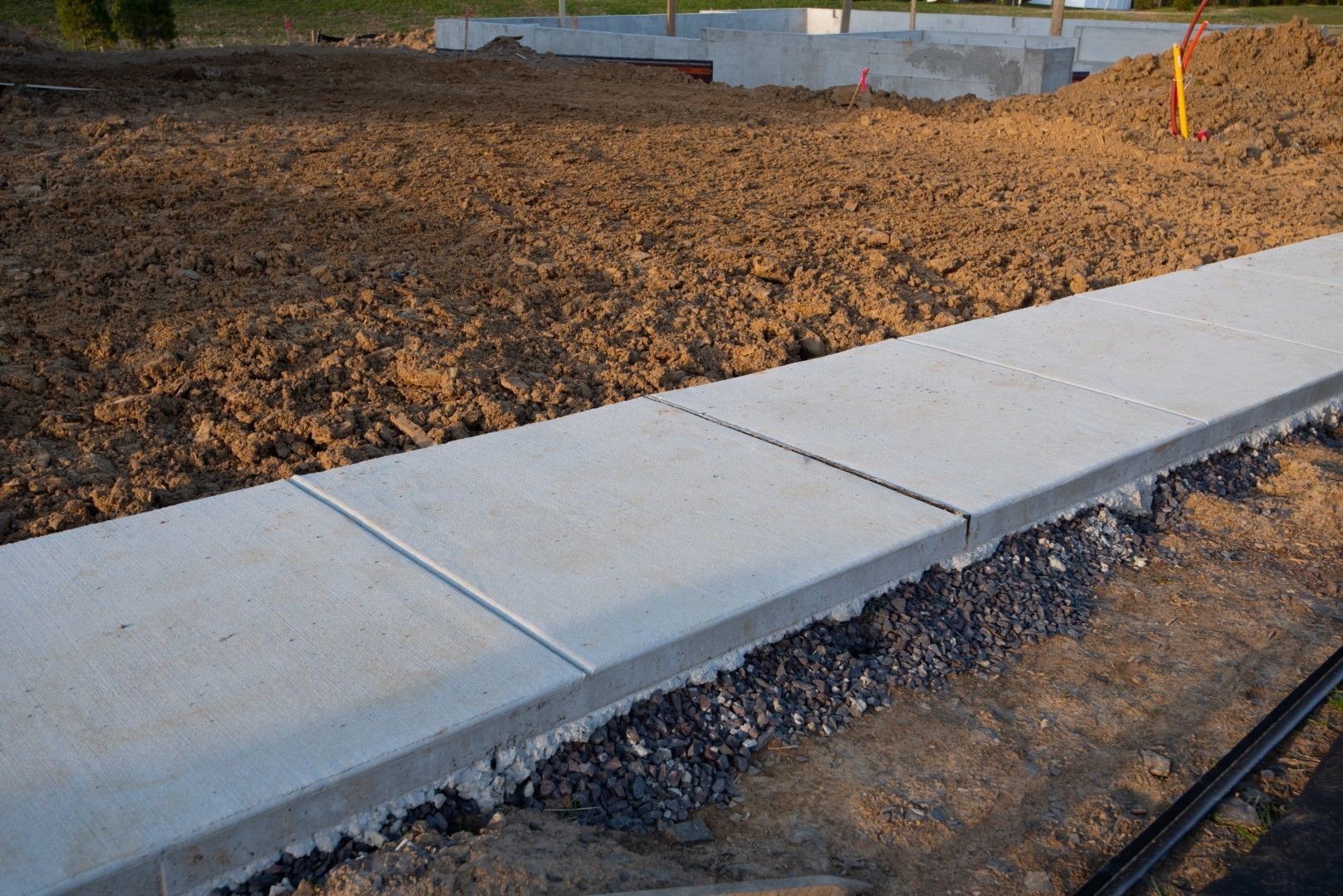 A sidewalk is being built in a dirt field