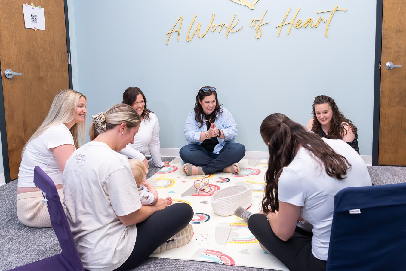 Parents and therapists sit together on a play mat, pregnancy anxiety support in Bergen County NJ