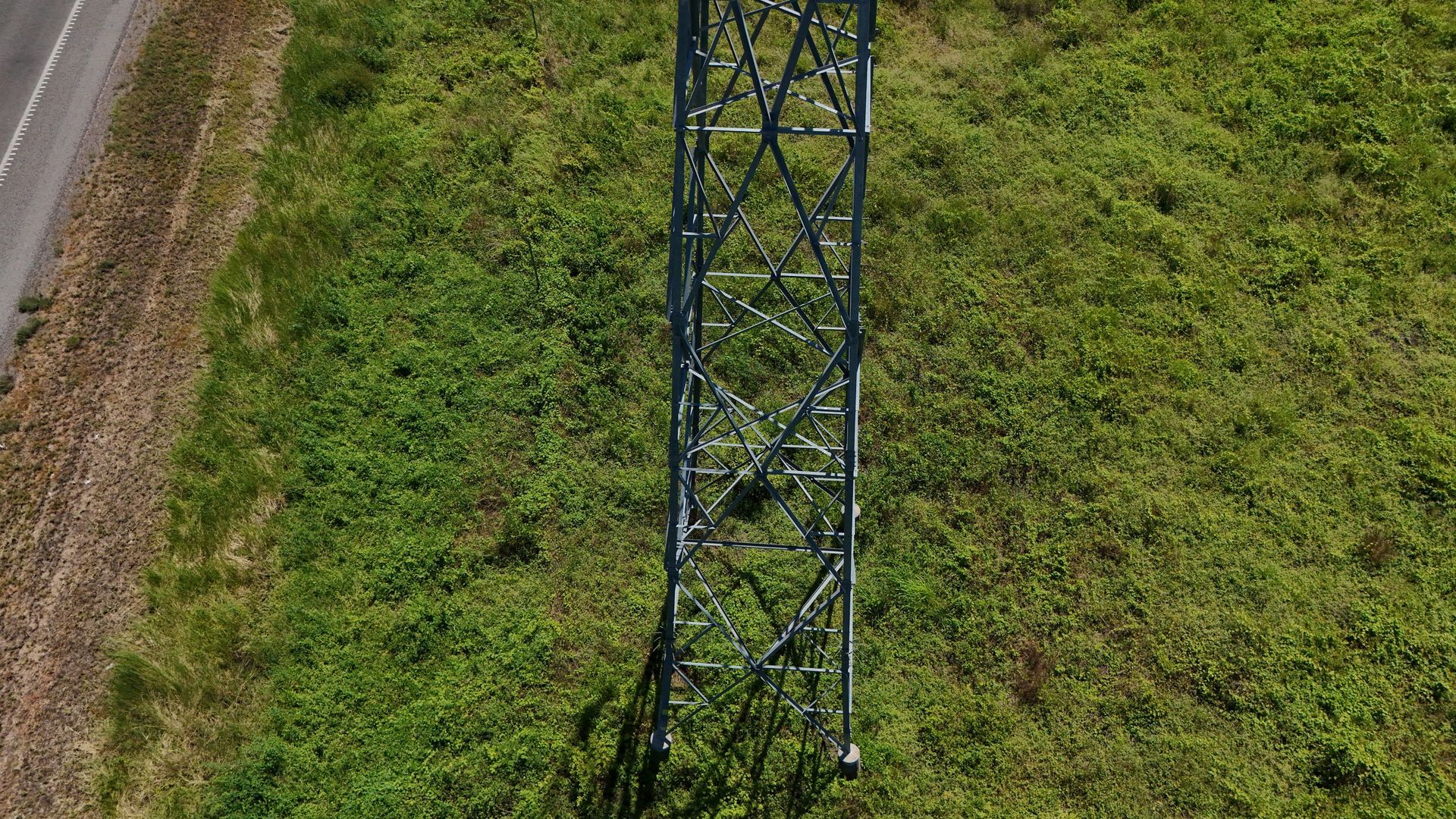 Blue Metal Tower in a Grassy Field Beside a Dirt Road — UAScend Aerial Solutions in Townsville, QLD