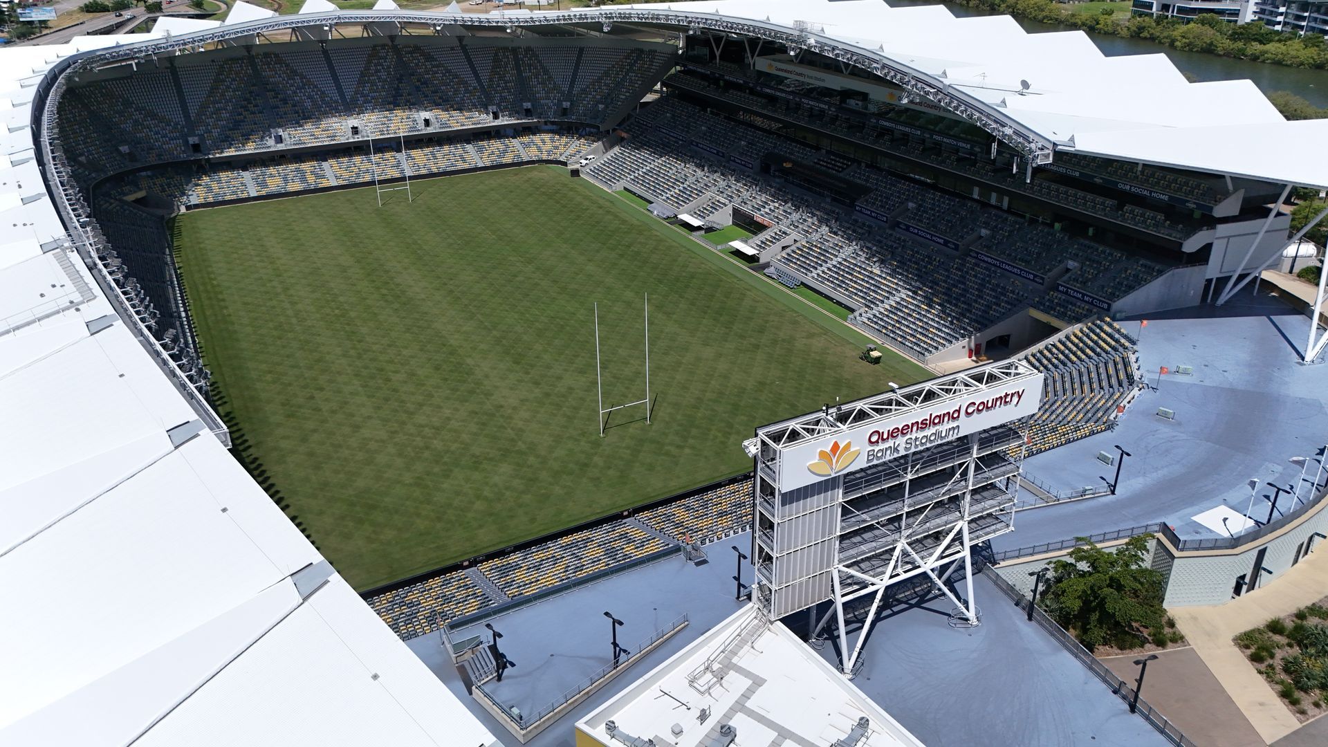 Aerial view of an empty rugby stadium with green field, seating stands, and a scoreboard — UAScend Aerial Solutions in Townsville, QLD