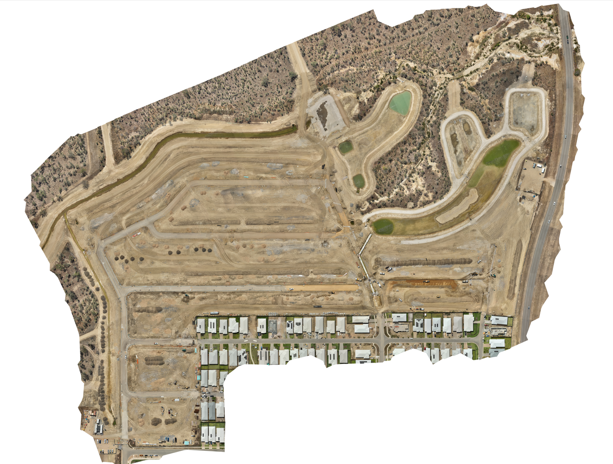 Aerial view of a construction site with graded roads, lots, and a few green retention ponds.