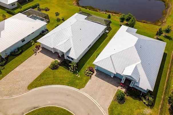 Aerial View of Three White-roofed Houses Beside a Curved Road and a Pond— UAScend Aerial Solutions in Townsville, QLD
