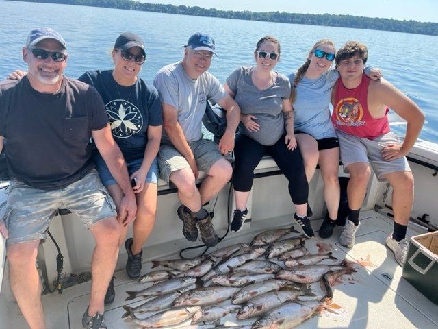 A group of people sitting on a boat with fish