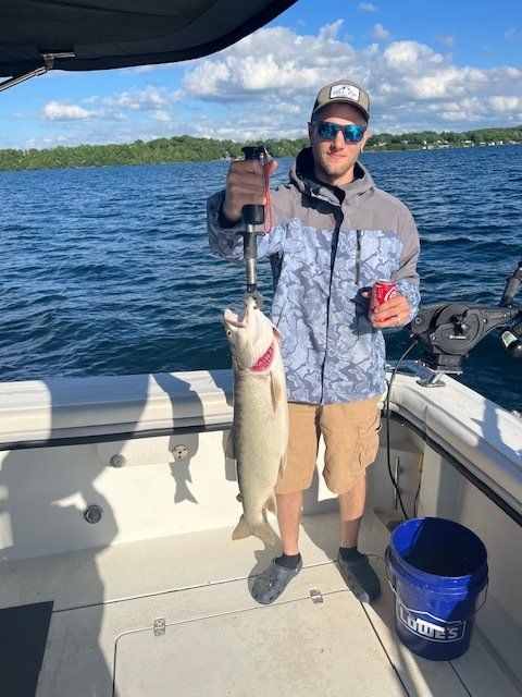 A man is standing on a boat holding a fish