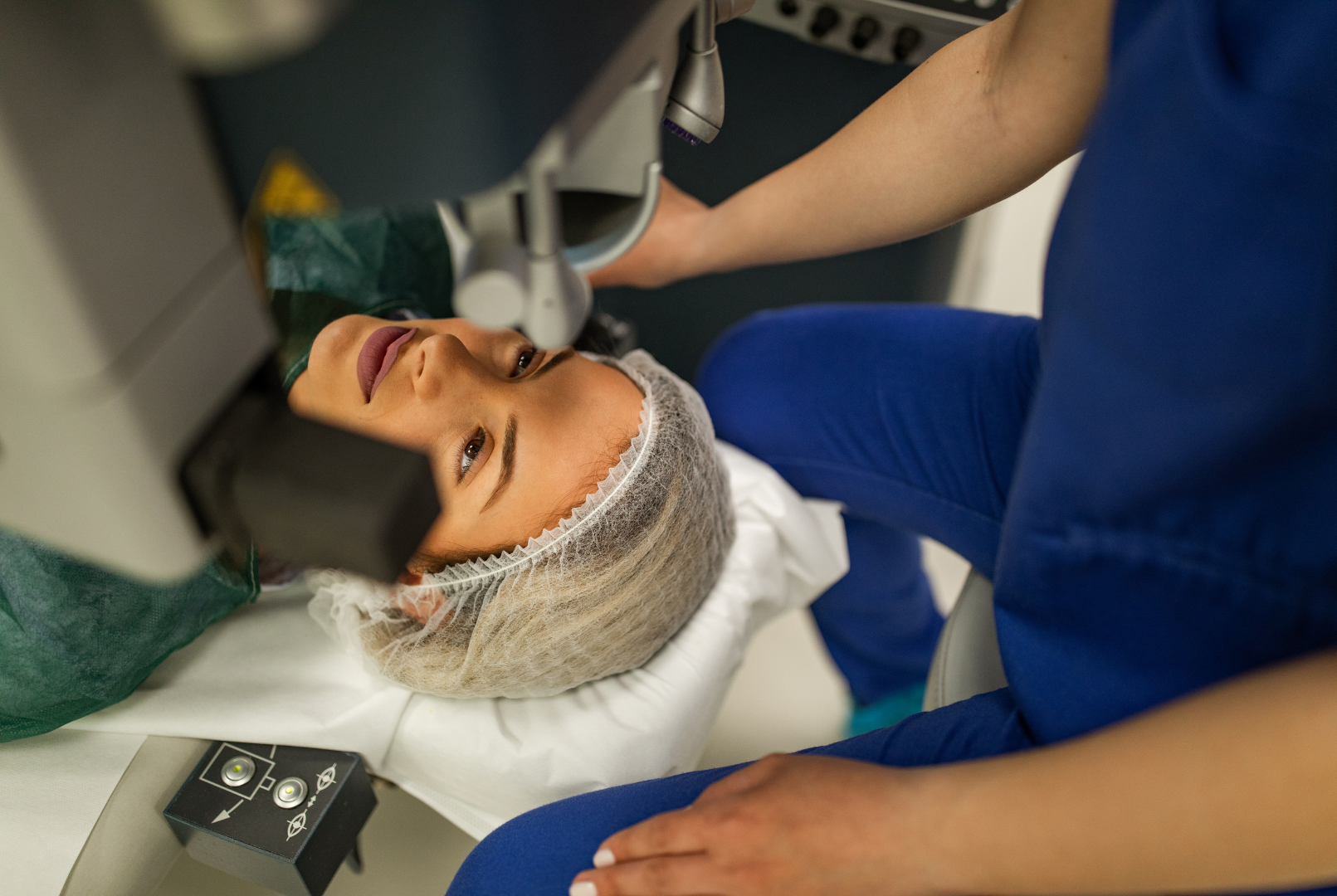 Dentist using a tool on a reclining patient in a blue bib during a dental procedure