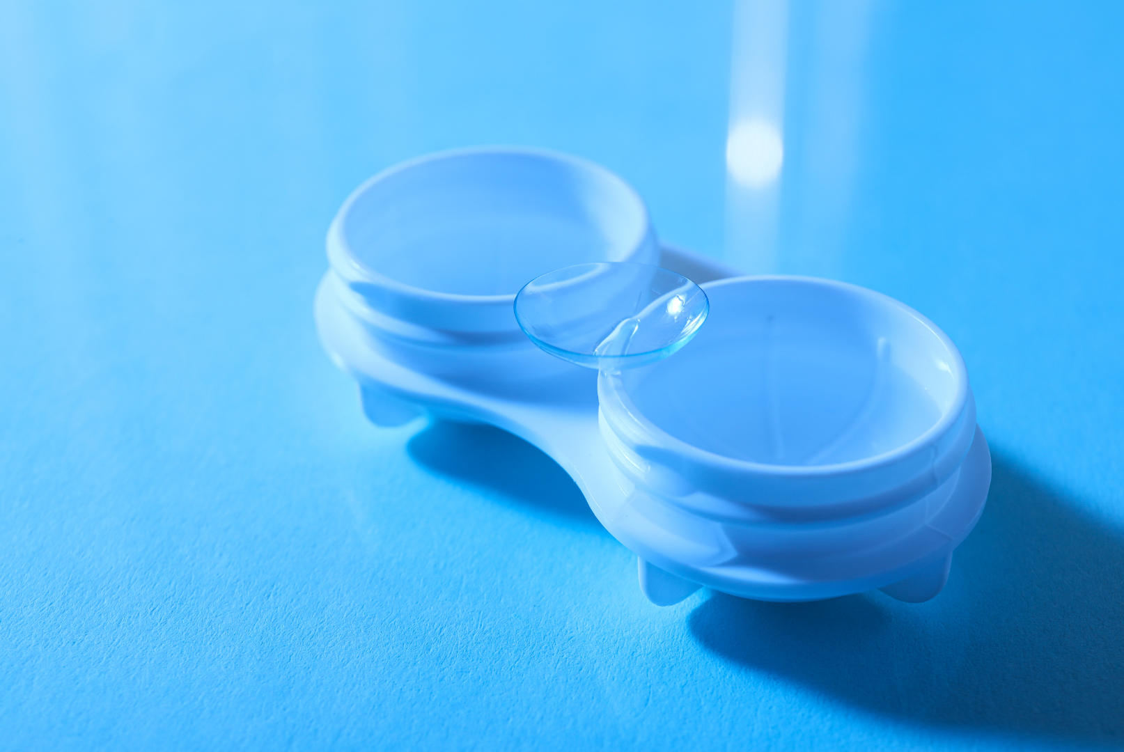 Clear contact lens case on blue surface