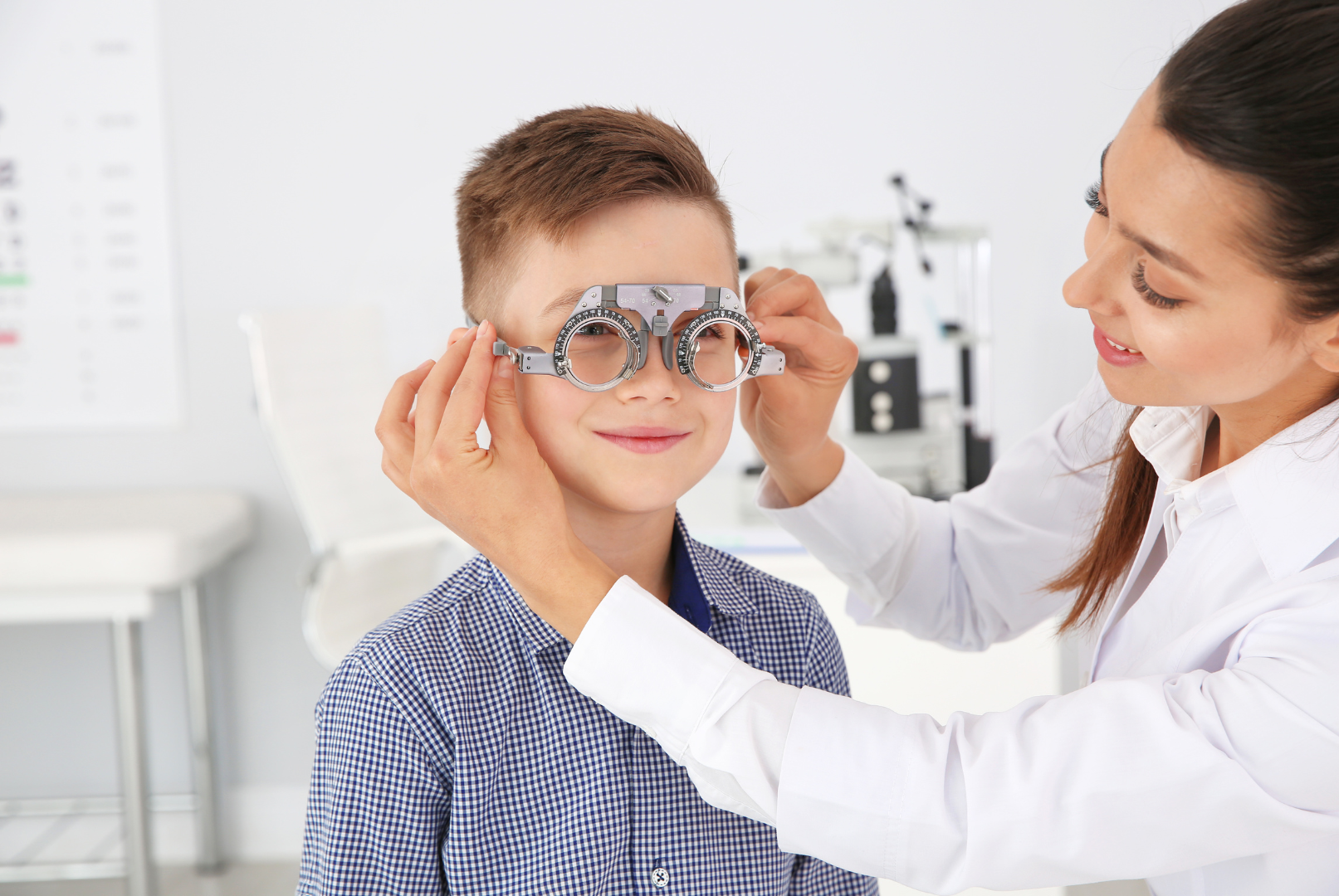 Optometrist adjusting glasses on a child in a bright exam room