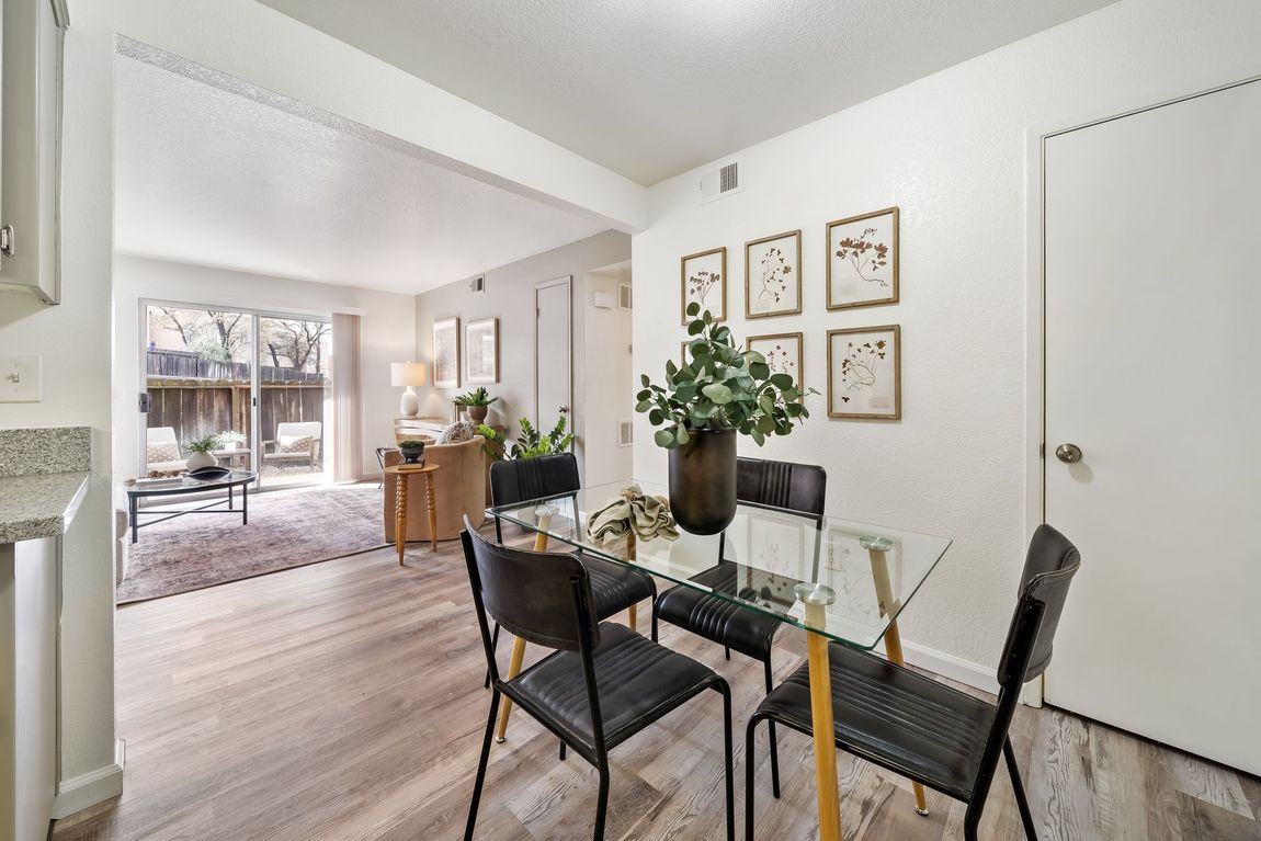 A dining room with a glass table and chairs in a house.