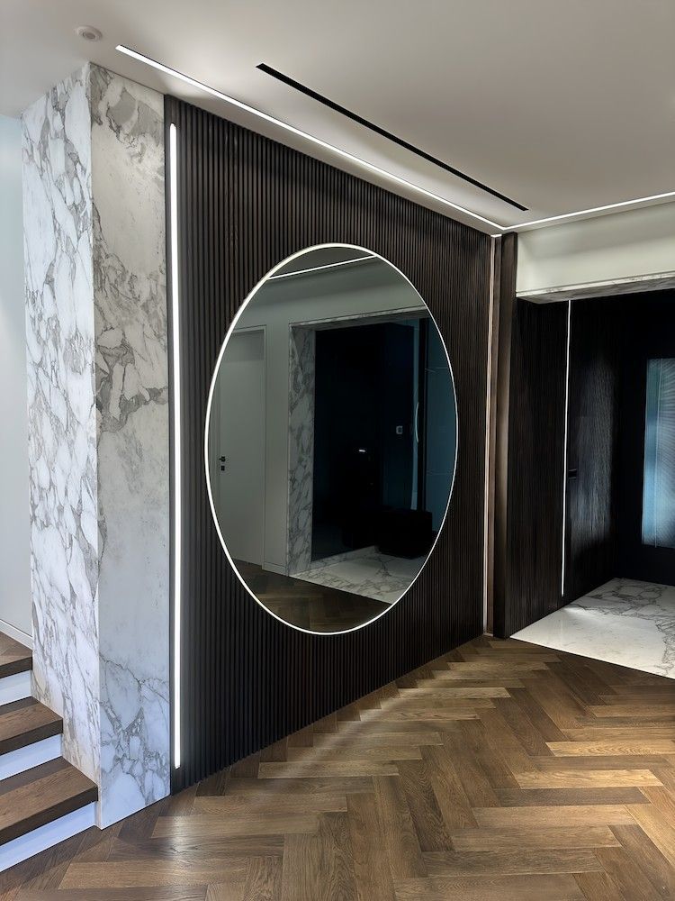 A Large Round Mirror is Hanging on a Wall in a Hallway — All Glass Balustrading Systems in Wetherill Park, NSW
