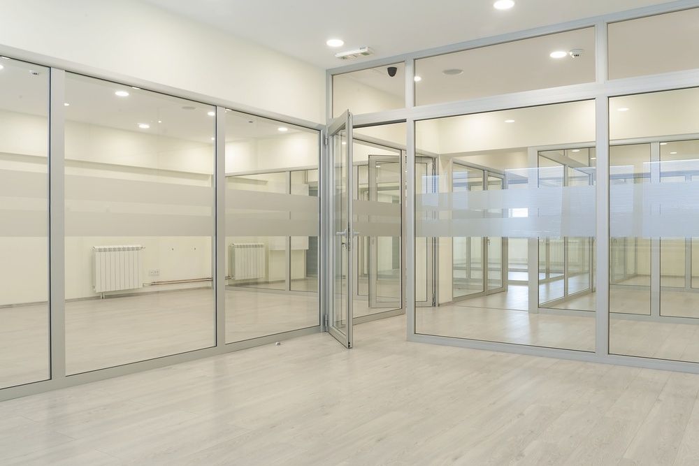 An Empty Room With a Lot of Glass Doors and Windows — All Glass Balustrading Systems in Wetherill Park, NSW
