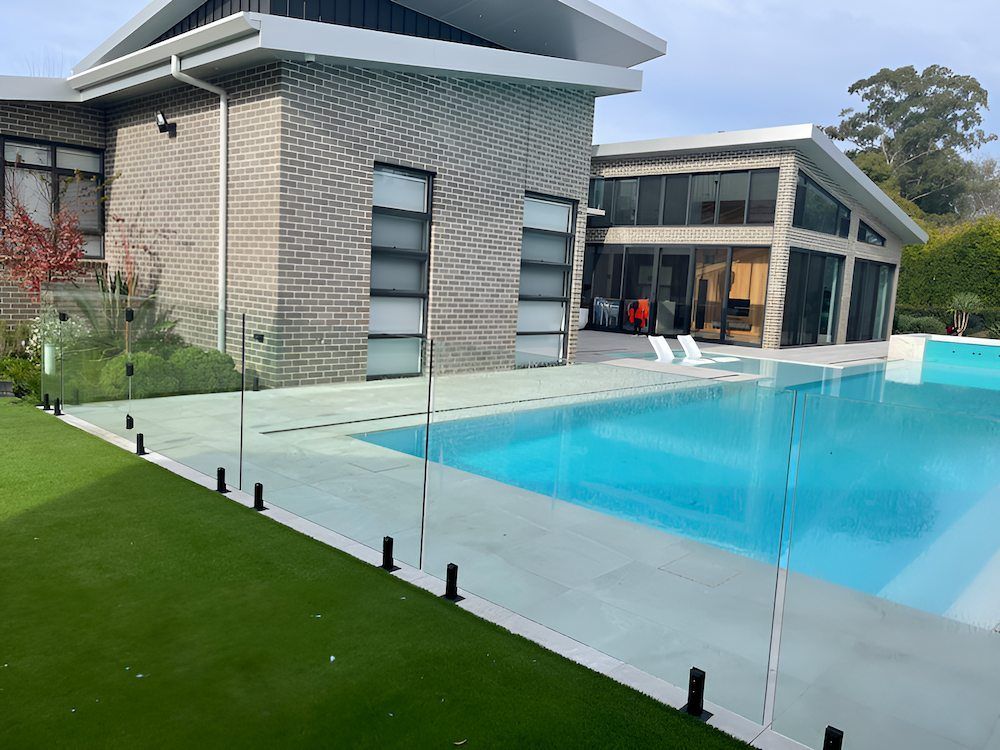 There is a Large Swimming Pool in the Backyard of a House — All Glass Balustrading Systems in Coogee, NSW