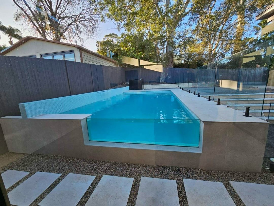 Rectangular Pool With Glass Side, Surrounded by Gravel and Pavers — All Glass Balustrading Systems in Wetherill Park, NSW