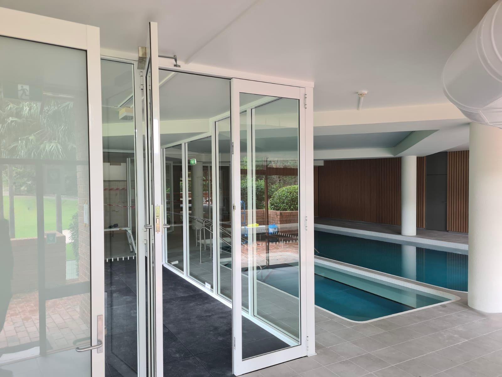 Glass Doors Open to Indoor Swimming Pool — All Glass Balustrading Systems in Wetherill Park, NSW