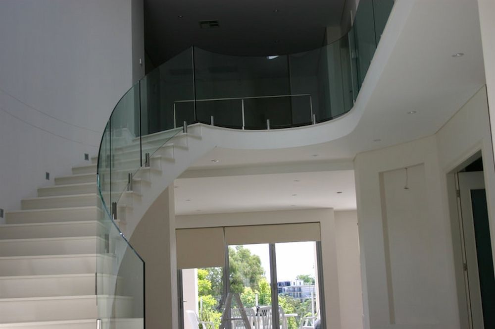 A White Staircase With a Curved Glass Railing — All Glass Balustrading Systems in Bondi, NSW