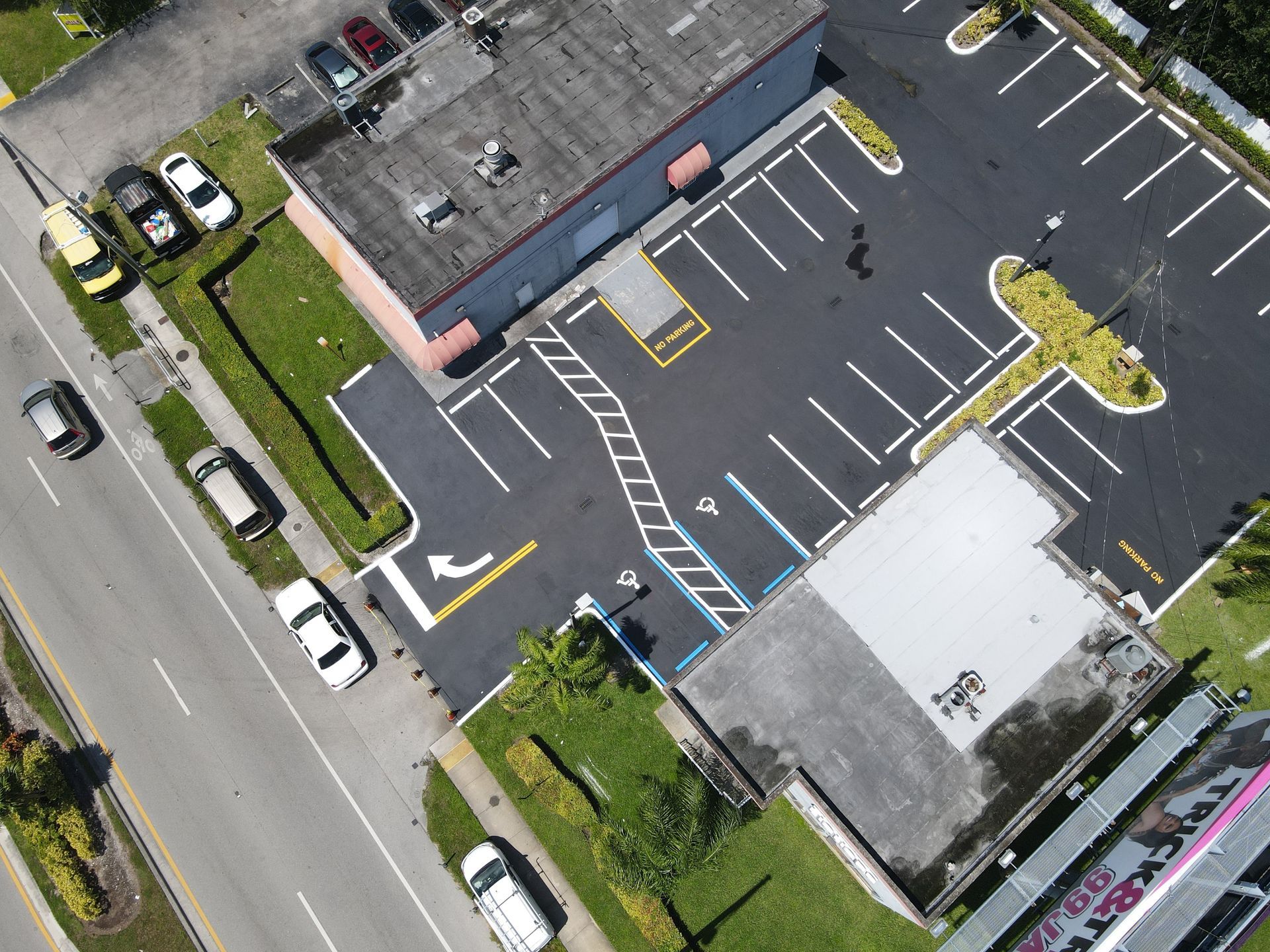 An aerial view of a commercial parking lot with designated handicap-accessible parking spaces marked in blue.