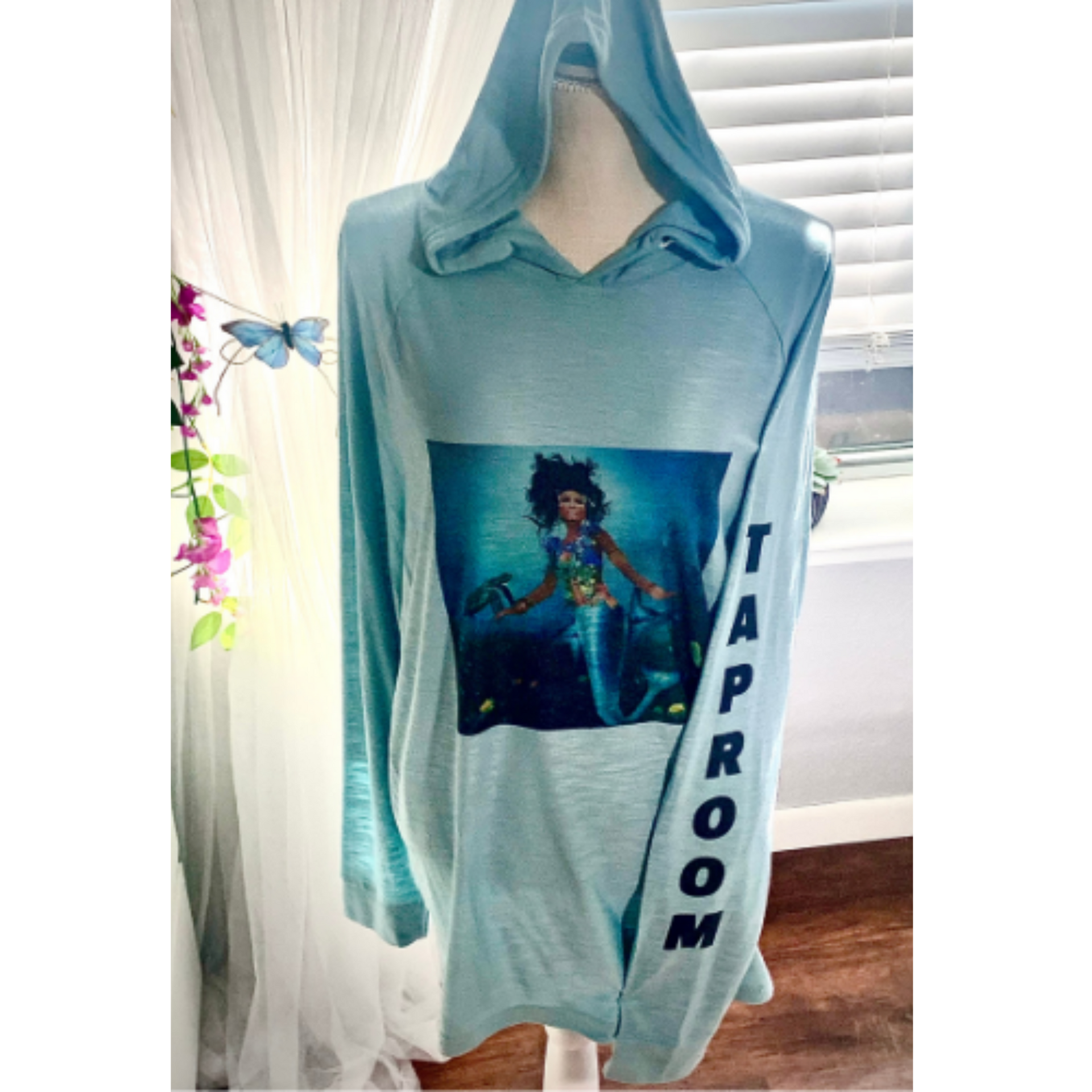 Light blue hooded sweatshirt with a graphic print and “HARPOON” down the sleeve on a mannequin
