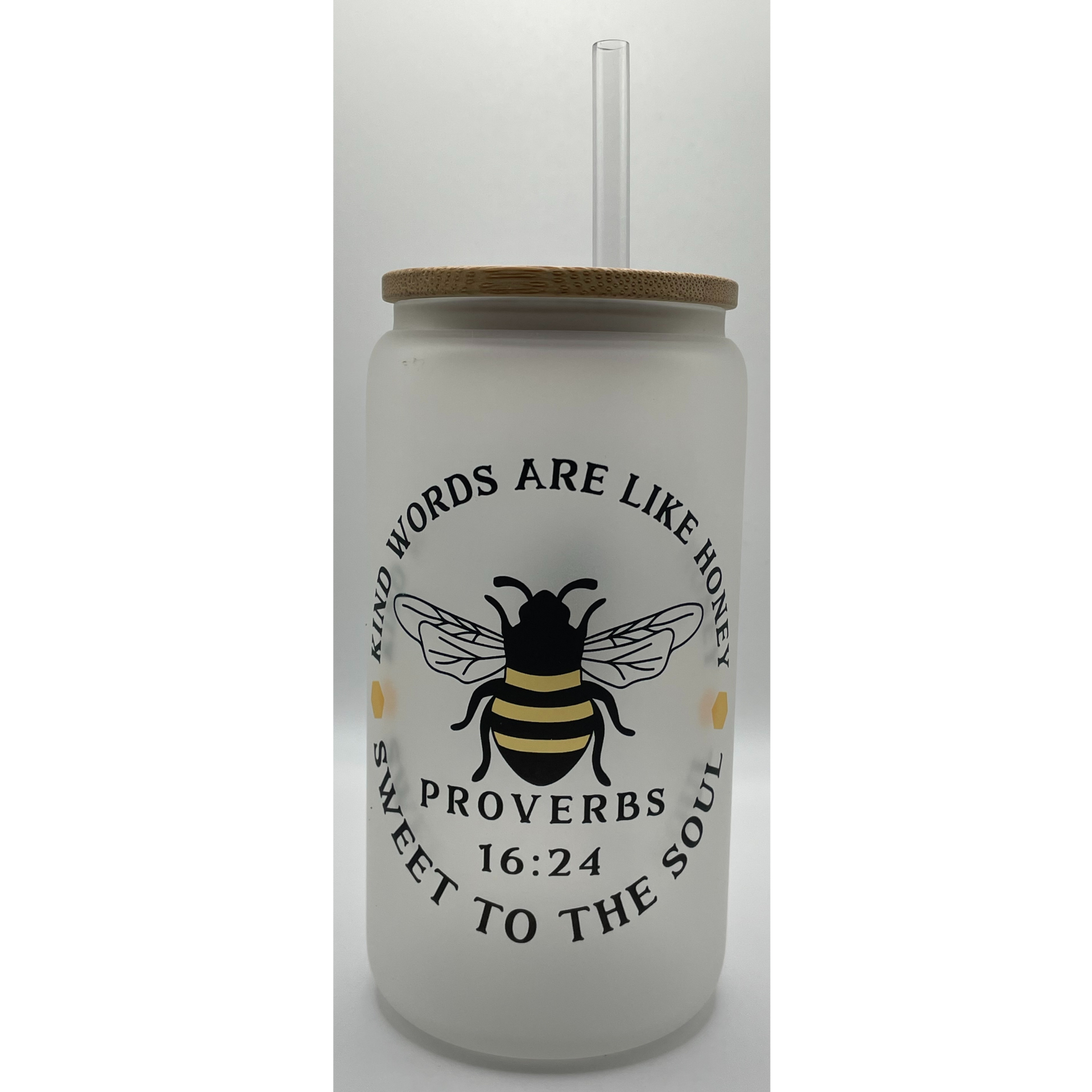 Frosted glass cup with wooden lid, bee graphic, and Bible verse text on white background