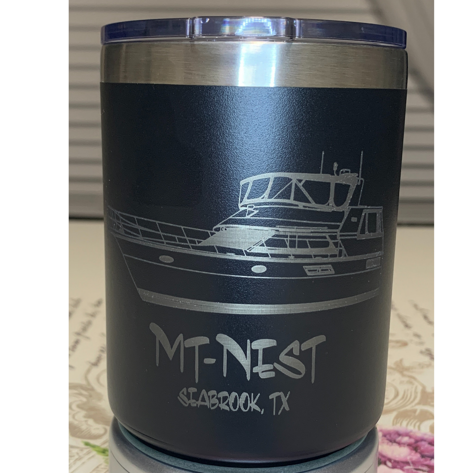 Black insulated tumbler with a white boat graphic and “MT-NEST, CEDAR CREEK TX” text