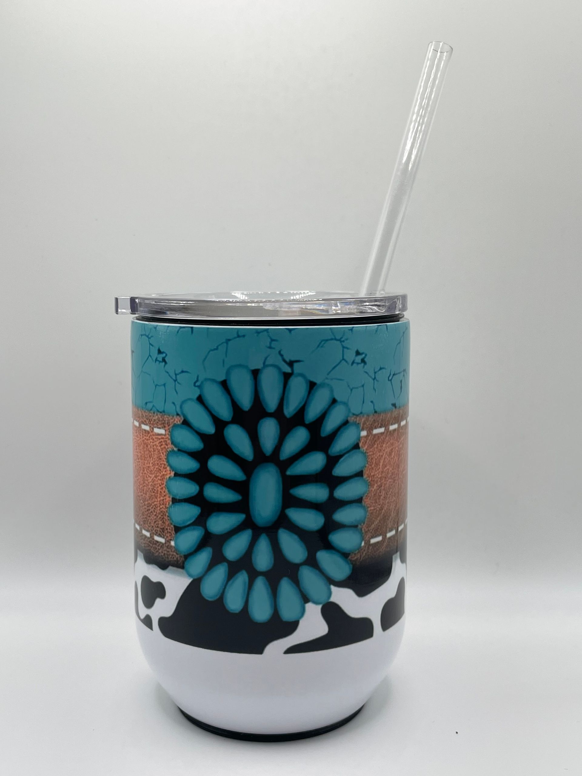 Decorative turquoise and black tumbler with a straw on a white background