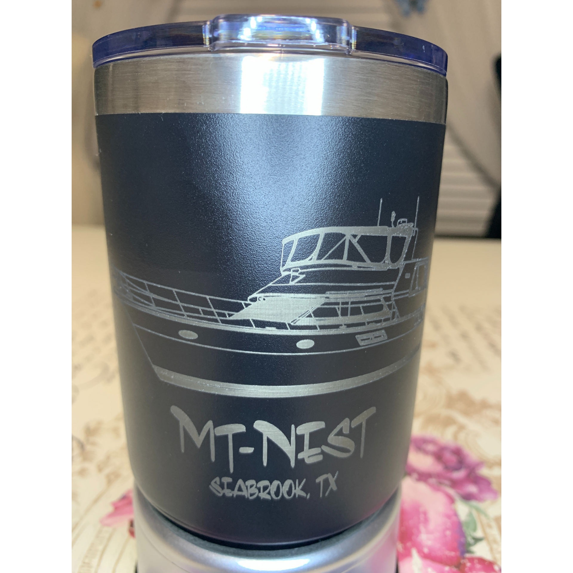 Black tumbler with boat graphic and “MT-NEST” text on a table