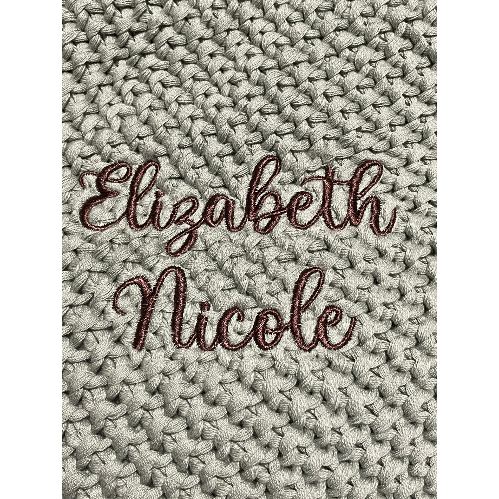 Brown cursive name “Elizabeth Nicole” on a textured white knit background