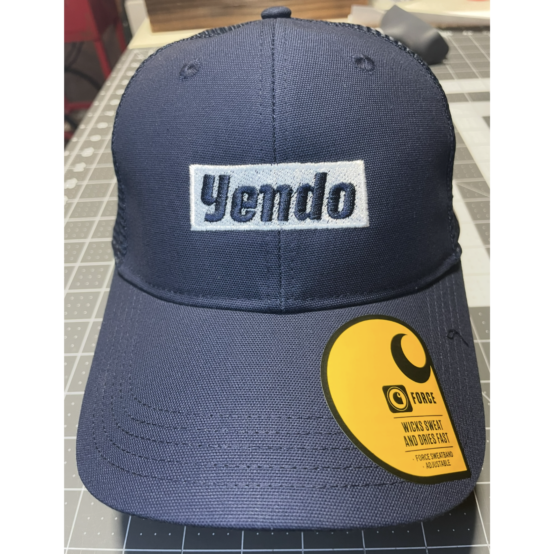 Navy blue Yenda baseball cap with a yellow product tag on the brim