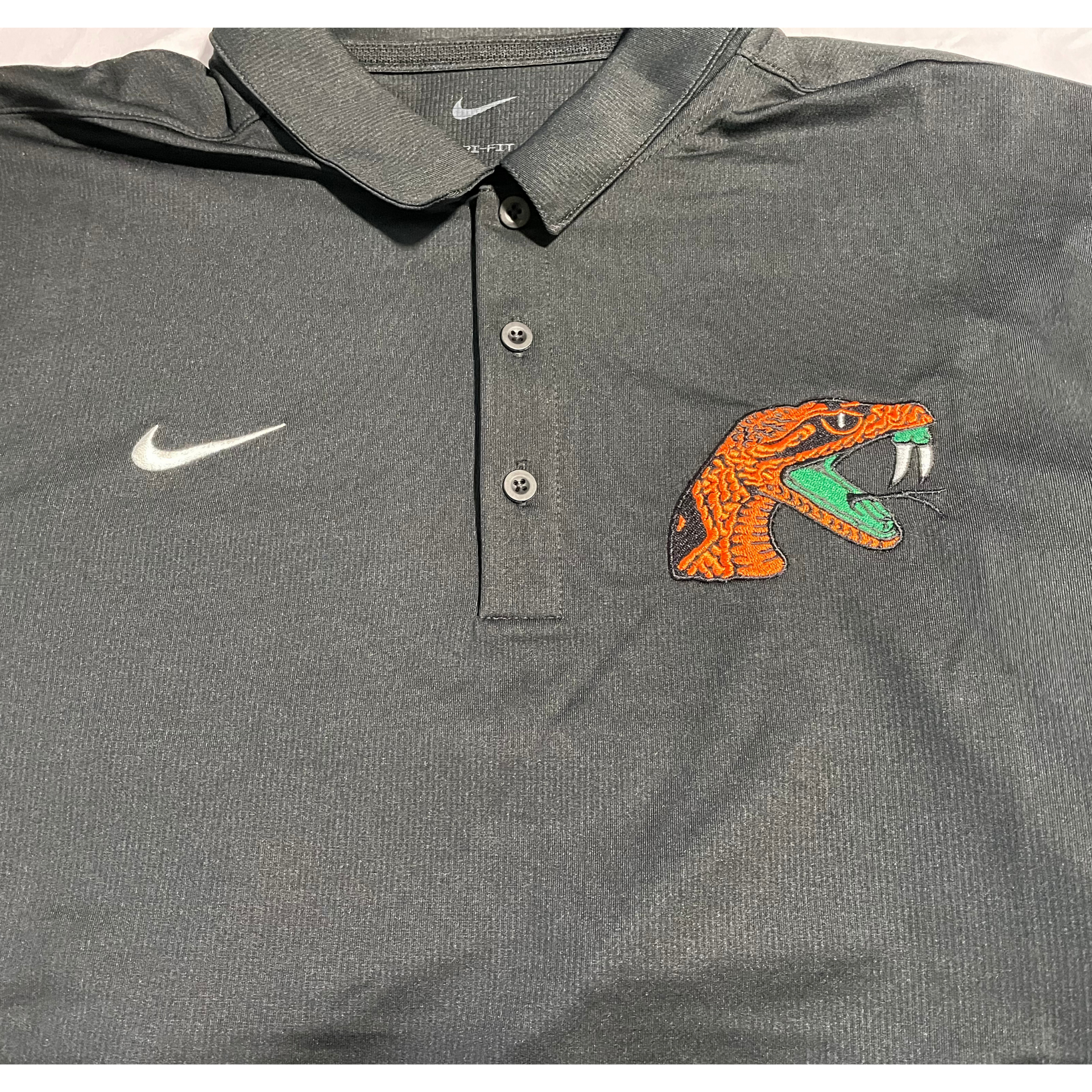 Black Nike polo shirt with white swoosh and orange-and-teal Gator logo on the chest