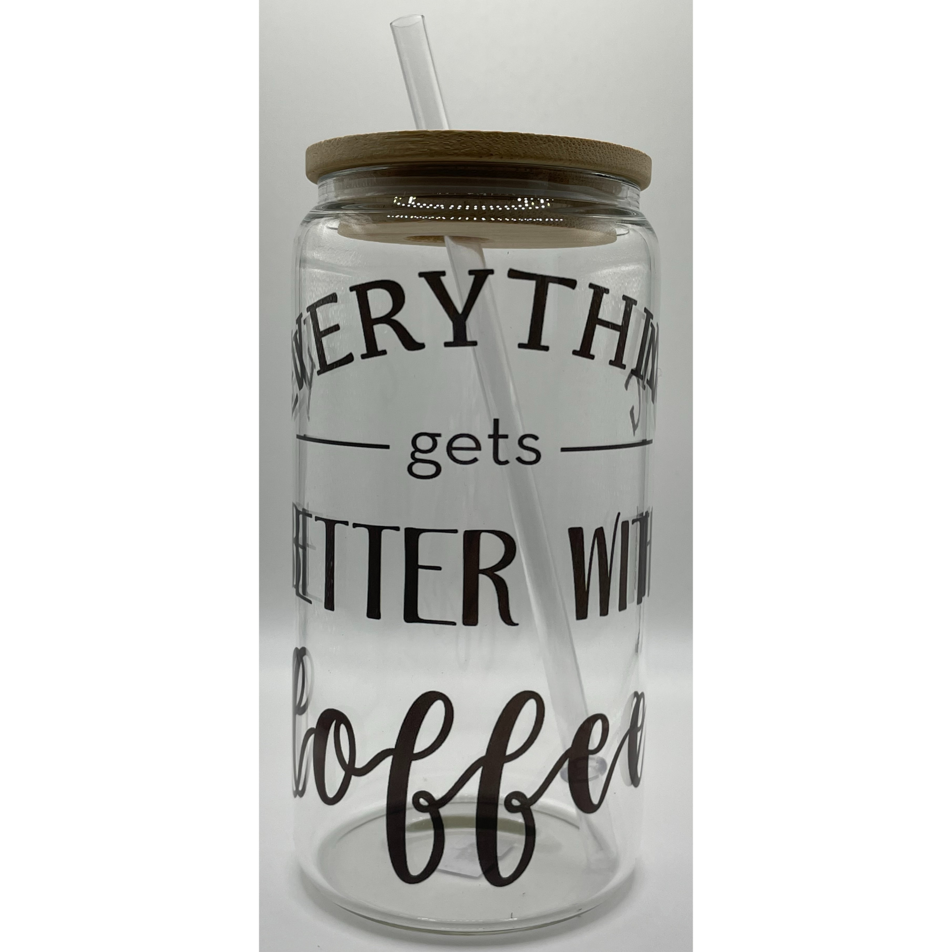 Clear glass jar with brown lid and straw, labeled “everything gets better with coffee”