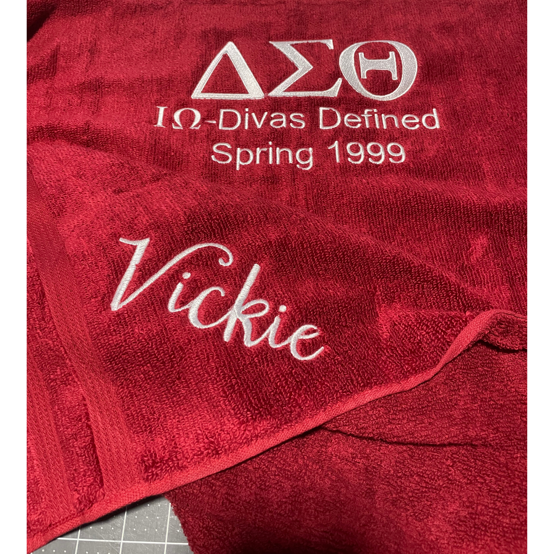 Red sorority blanket embroidered with Delta Sigma Theta, “Ω Divas Defined Spring 1999,” and “Vickie”