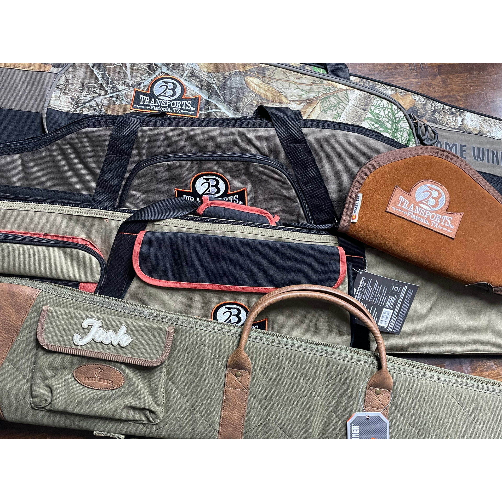 Assorted hand tool bags in black, olive, and brown, stacked together on a surface.