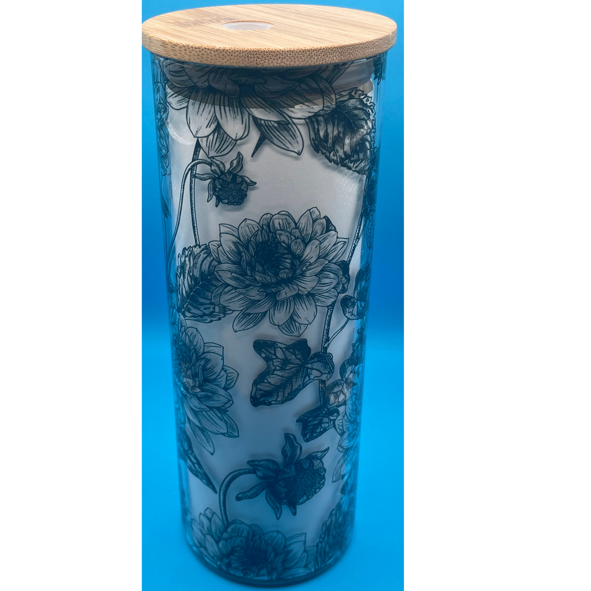 Blue floral-patterned cylindrical candle in a glass jar with a wooden lid