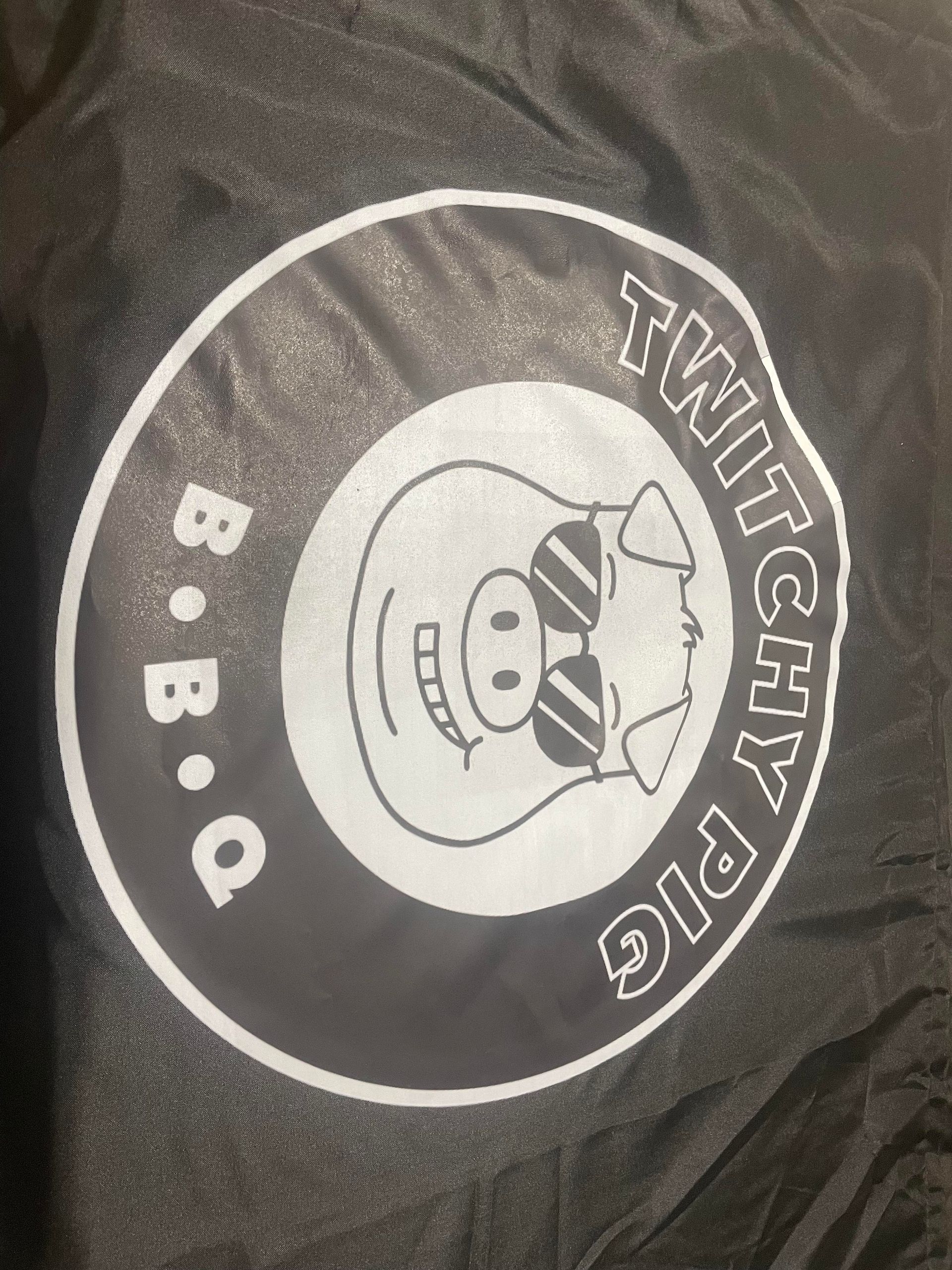 Black T-shirt with a circular BBQ logo and a chef illustration reading “TWITCHY PIG” and “B.B.Q.”