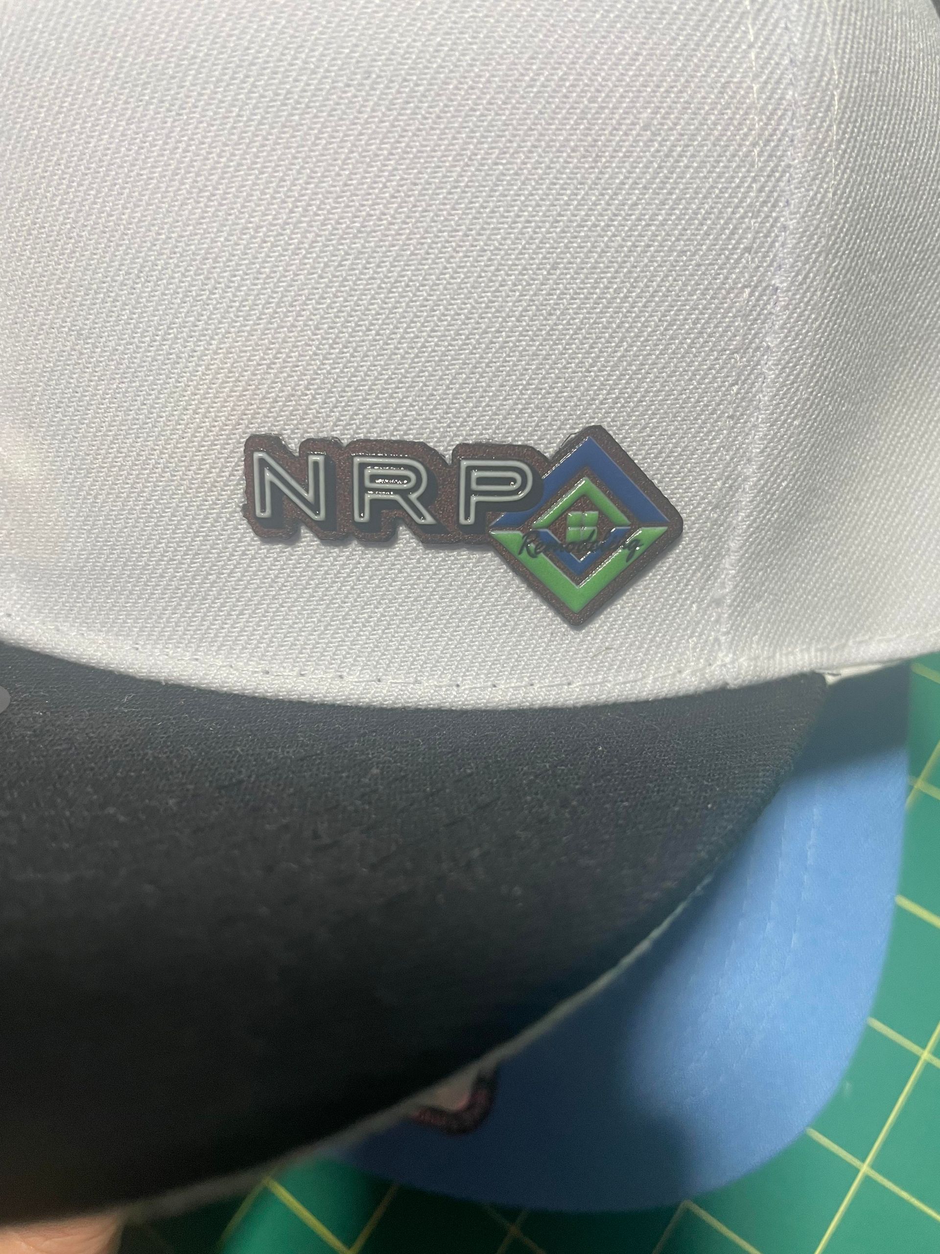Close-up of an NRP logo patch on a white textured shirt with a blue object below