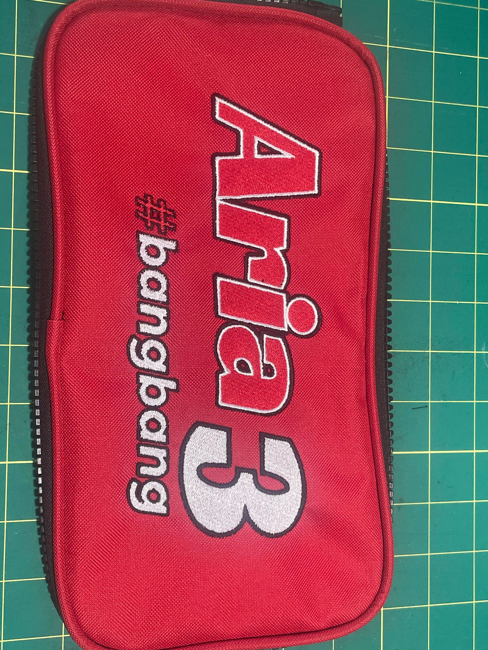 Red Aria 3 Bongbong zippered pouch on a cutting mat