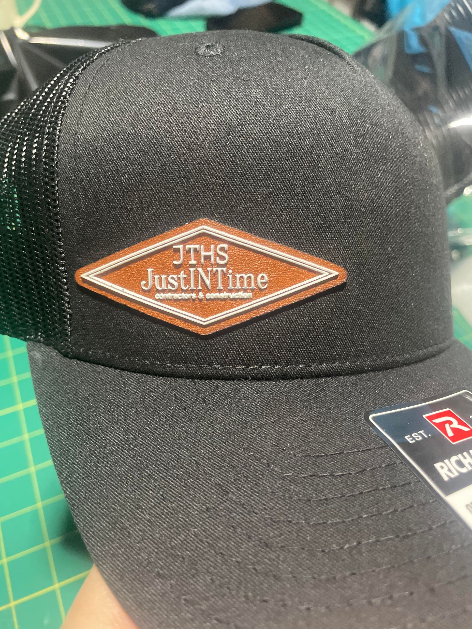 Black textured baseball cap with an orange diamond logo on the front.