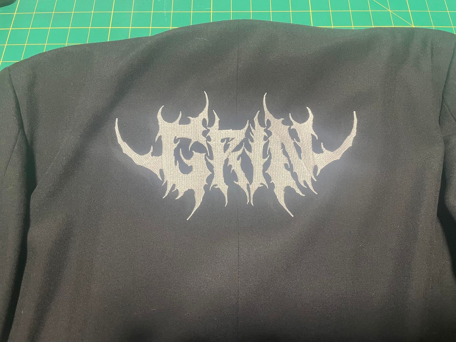 Black fabric with a white spiky logo printed in the center.