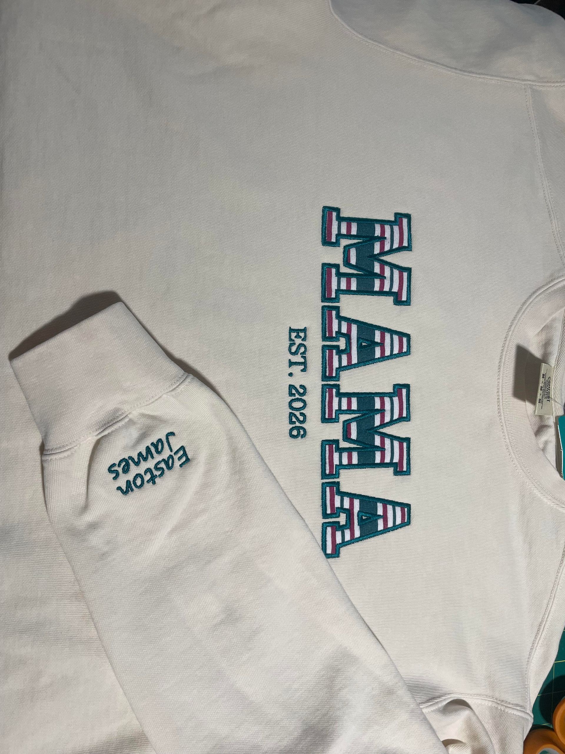 White T-shirt with blue “MAHA” graphic and “EST. 2008” text, plus a tag reading “STAMPS.”
