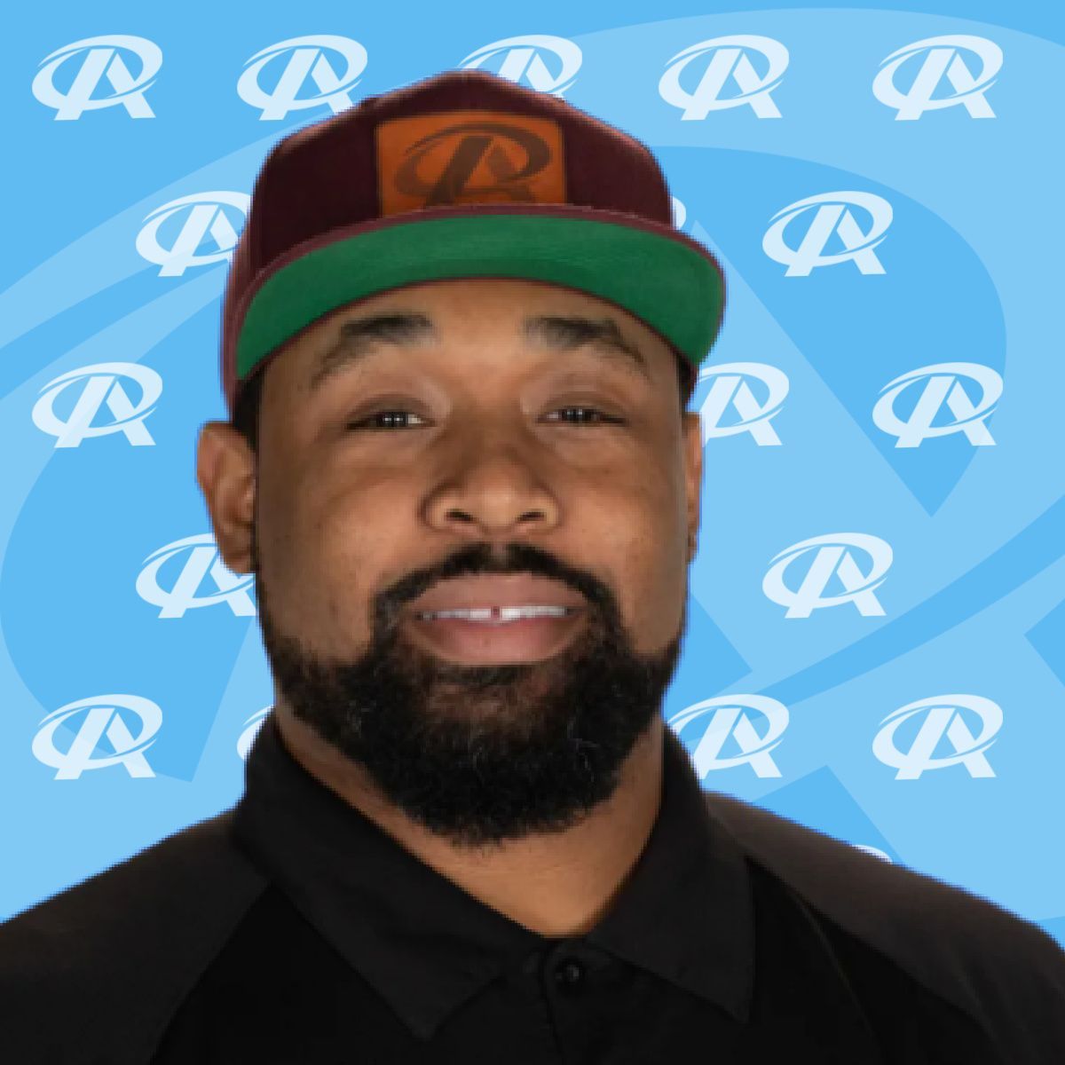A man with a beard wearing a hat with the letter p on it