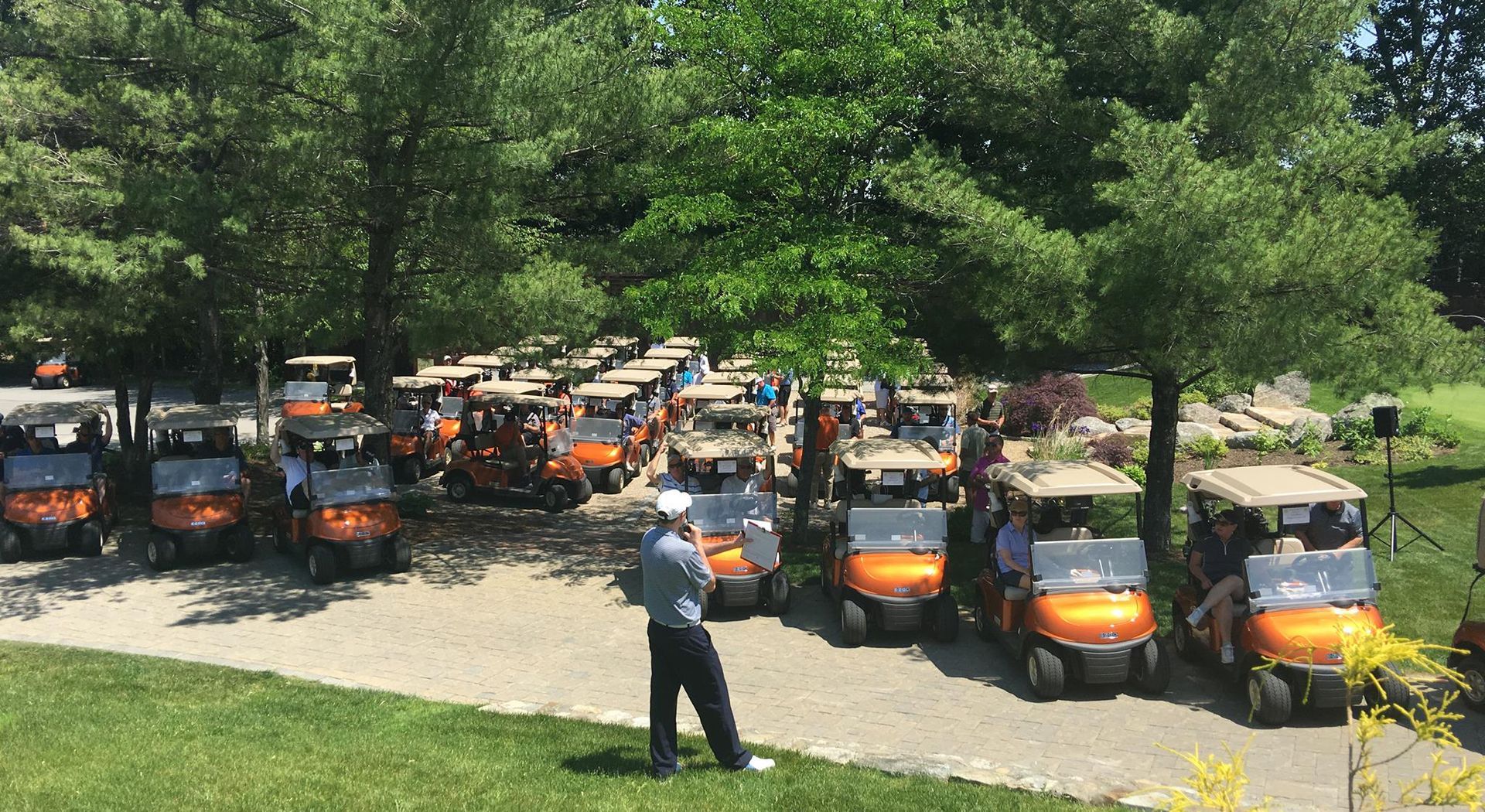 A man is standing in front of a row of golf carts.