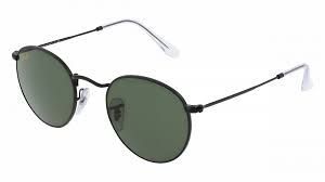 Un par de gafas de sol redondas con marco negro y lentes verdes sobre fondo blanco.