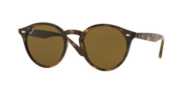 Un par de gafas de sol redondas con lentes marrones sobre un fondo blanco.