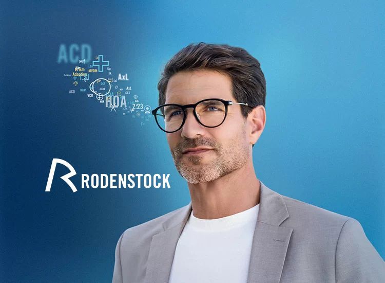 Un hombre que lleva gafas y un traje está parado frente a un logotipo de Rodenstock.
