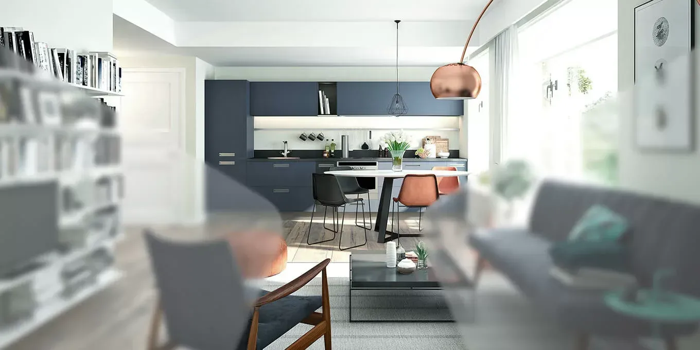 Una sala de estar con un sofá, sillas, una mesa y una cocina al fondo.