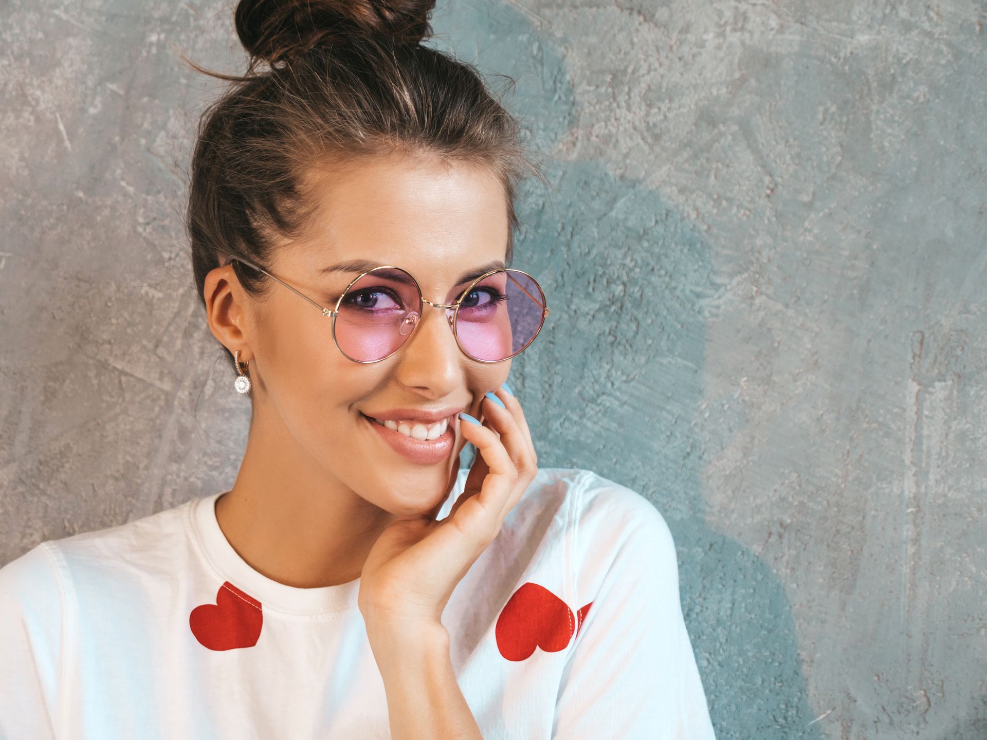 Una mujer que lleva gafas de sol y un moño está hablando por un teléfono móvil.