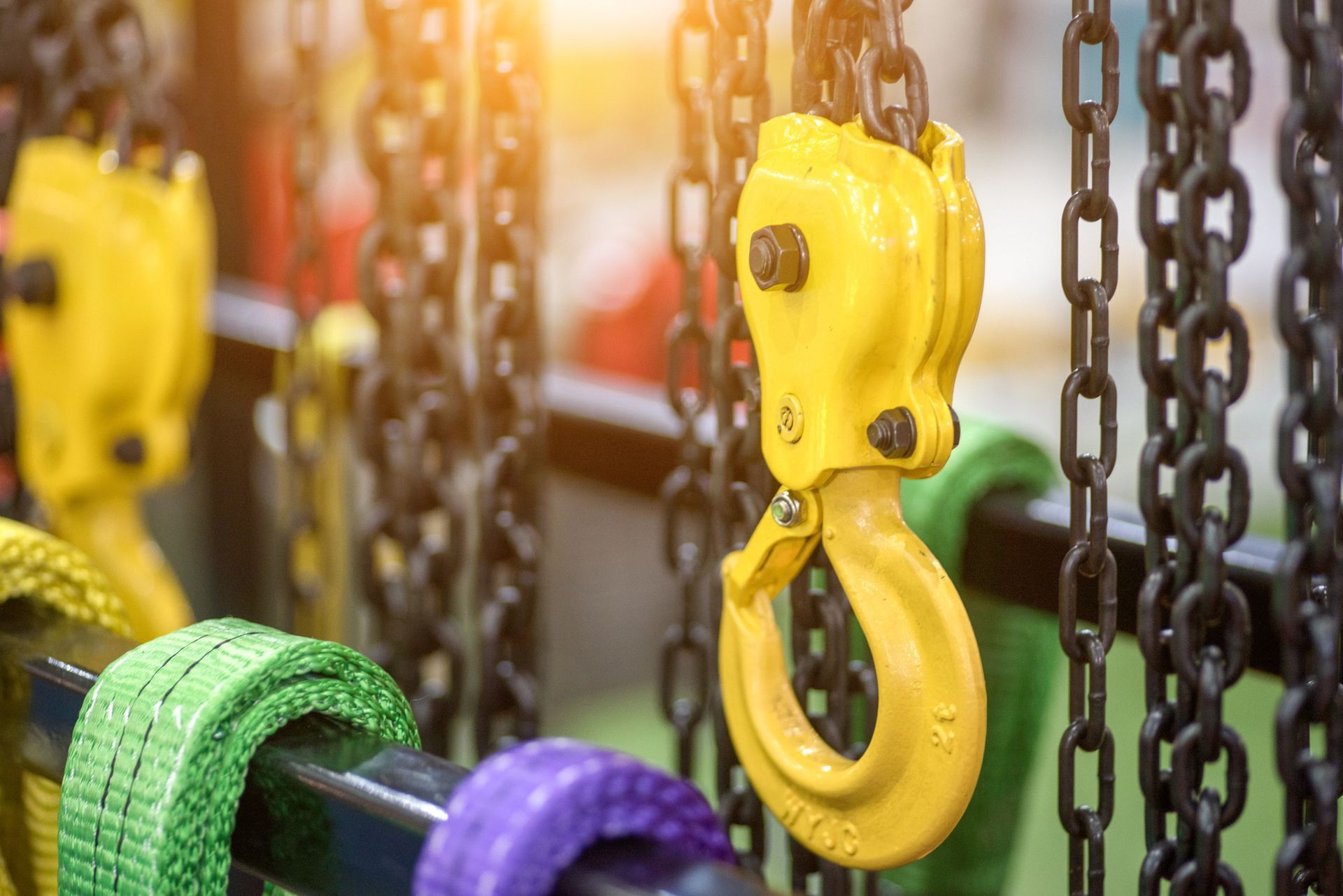 A close up of a yellow hook on a chain.